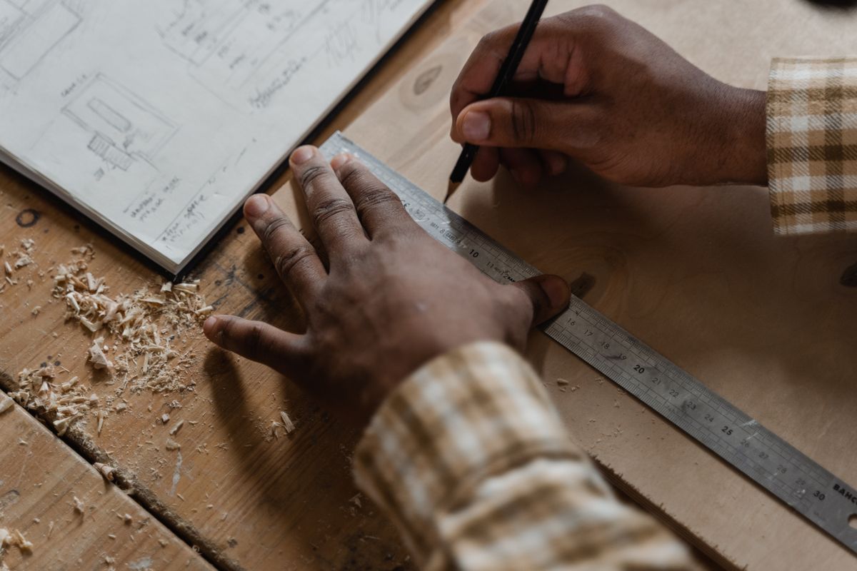 Hands carefully measuring and marking timber