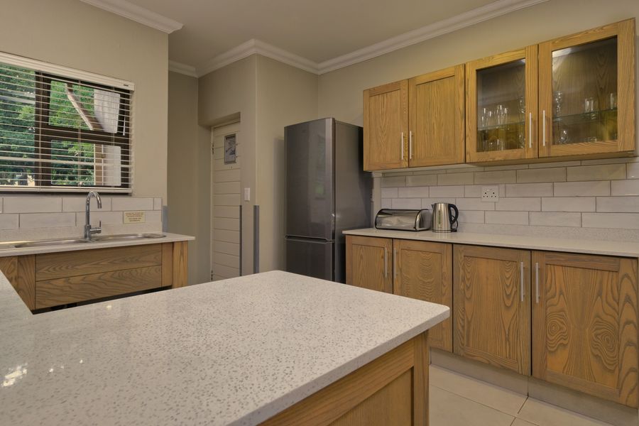 Fitted timber kitchen cabinets with stone worktops and a sink