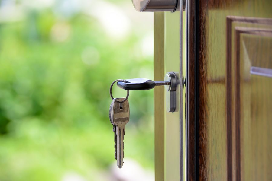 Keys inserted in a door lock beside its metal handle
