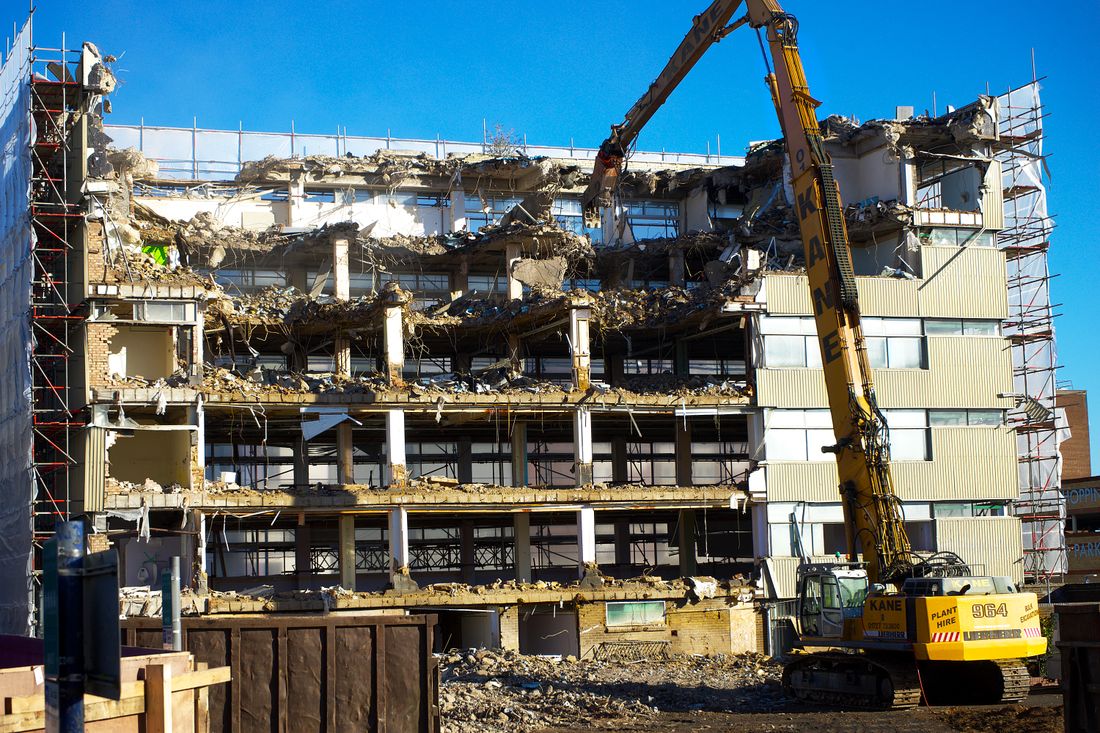 Excavator dismantling a building on a demolition site