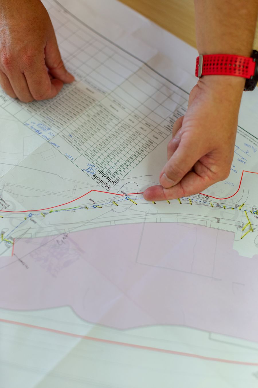 Engineer's hands checking a detailed construction drawing