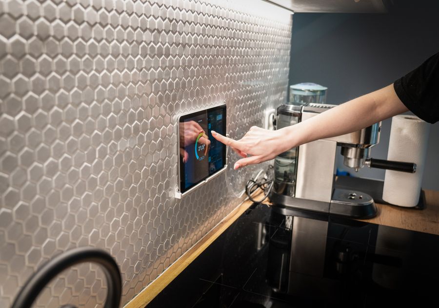 Hand adjusting a wall-mounted smart-home touchscreen control